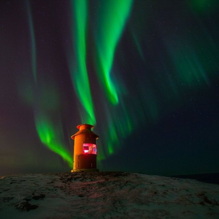 Súgandiseyjarviti baðar sig í Norðurljósum.