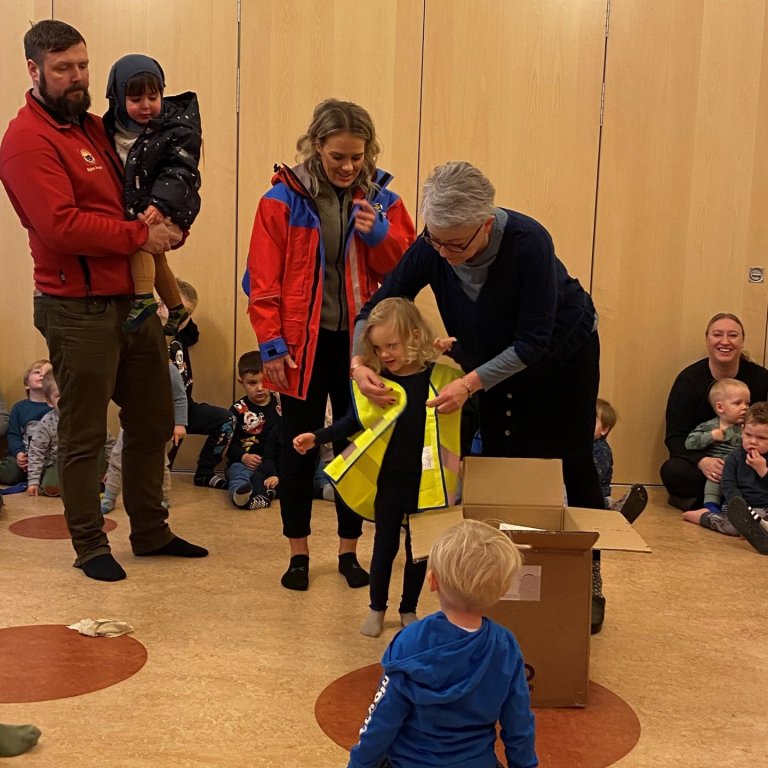 Sigrún, leikskólastjóri, mátar vesti á börnin.